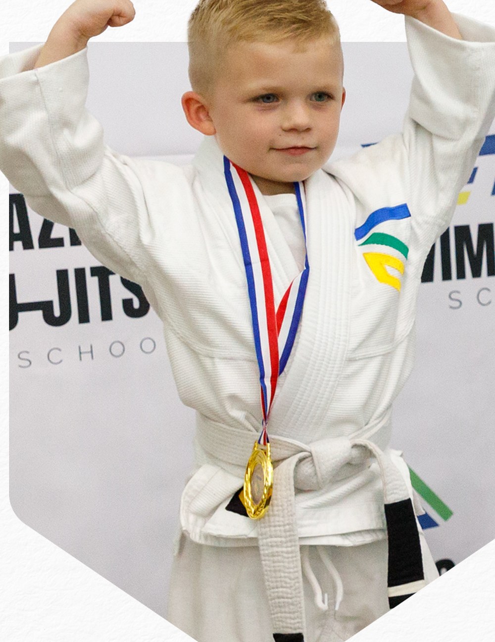 Young student flexing proudly with his first gold medal
